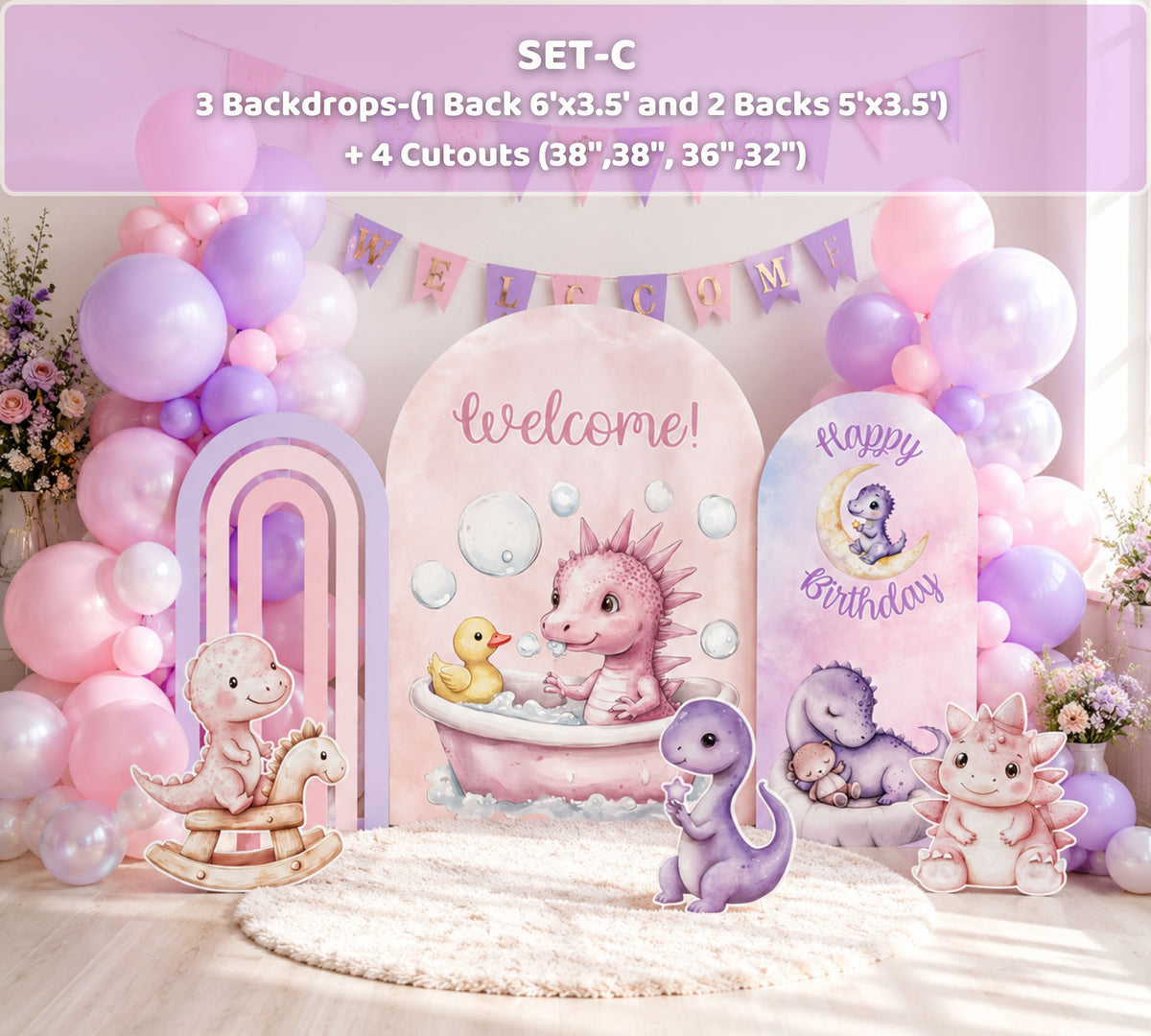 Pink baby dinosaur party backdrop with pastel arch panels, balloon garland and cute dino decorations for a girls birthday or baby shower.