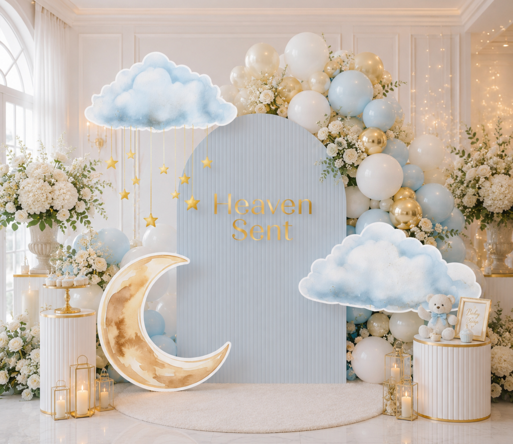 Heaven Sent baby shower setup with pale blue and ivory backdrop panels, moon cutouts and elegant neutral party decorations.
