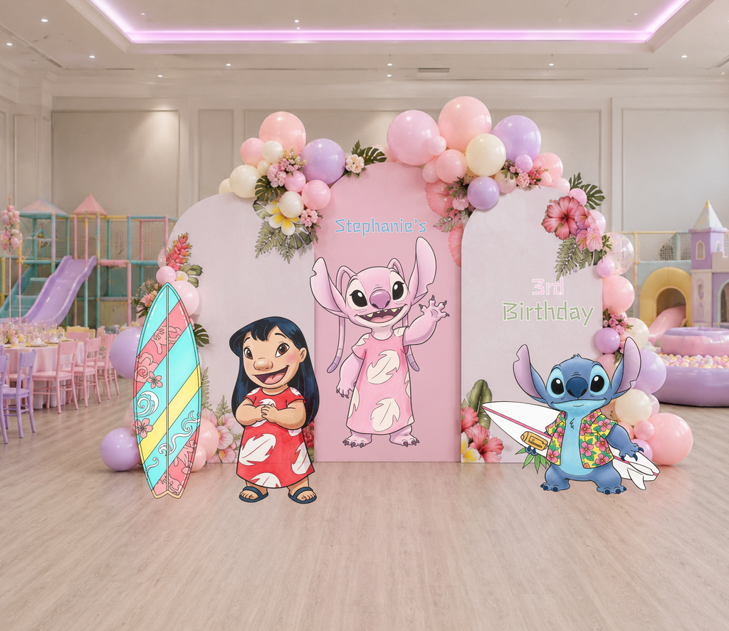 Pink tropical birthday backdrop with balloon clusters, hibiscus flowers and Hawaiian character cutouts for a colorful kids party.