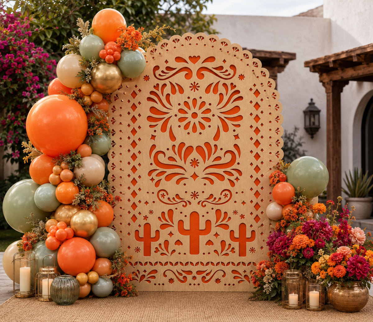 Terracotta papel picado backdrop with orange and green balloon garland for fiesta party decor