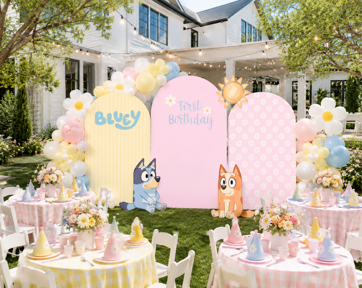 Outdoor puppy family birthday backdrop with pastel pink and yellow panels, balloon decor and personalized character party decorations.