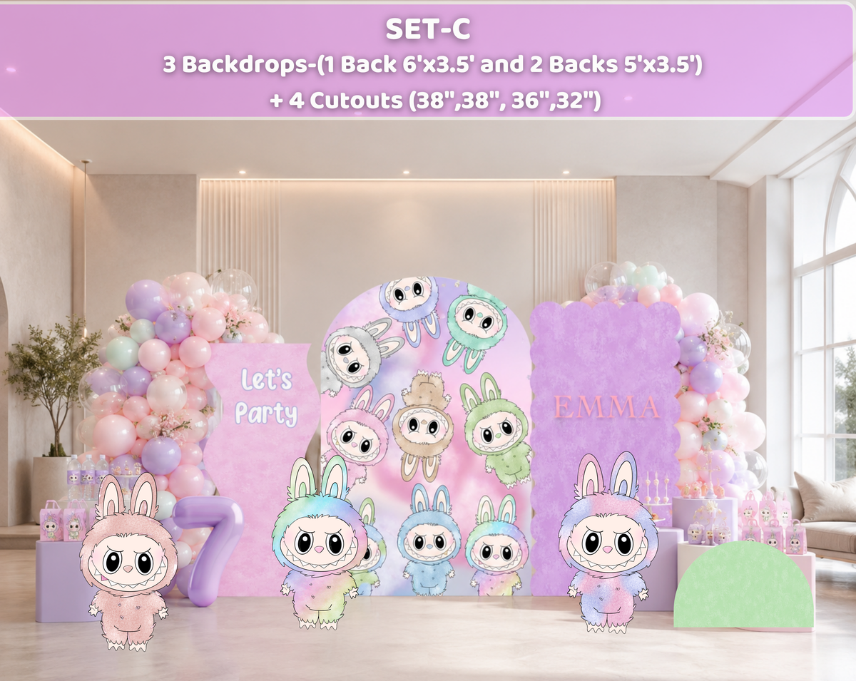 Pastel monster party backdrop with lavender panels, cute character cutouts and balloon decor for a personalized birthday setup.