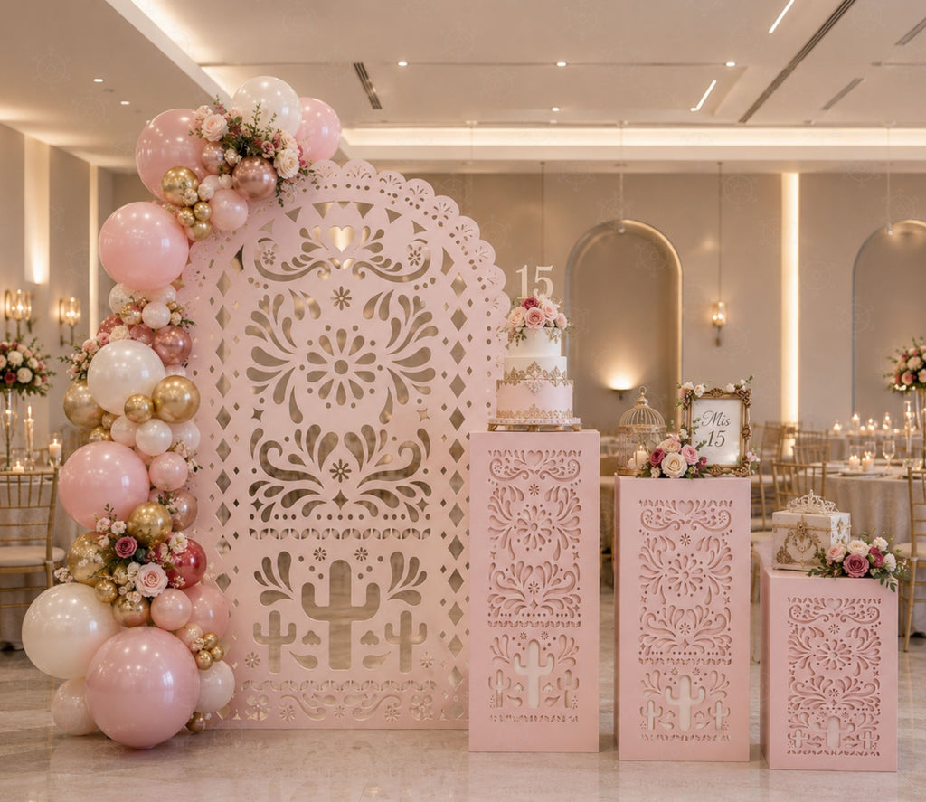 Pink Papel Picado backdrop and matching pedestal set styled with floral decor outdoors