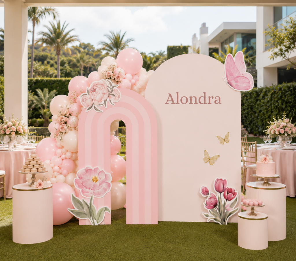 Personalized pink fairy backdrop with floral balloon decor, layered panels and magical first birthday party details.