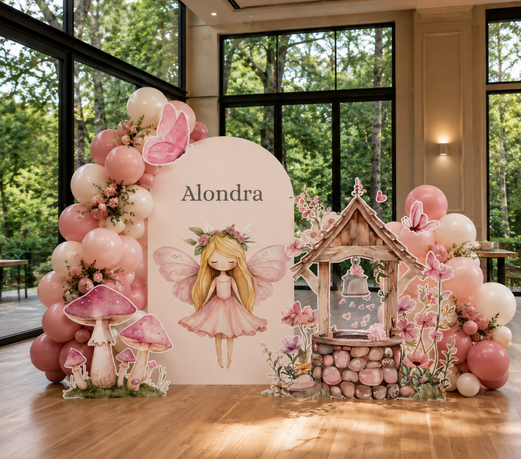 Pink fairy first birthday setup with personalized backdrop, floral garlands and whimsical woodland inspired party decor.
