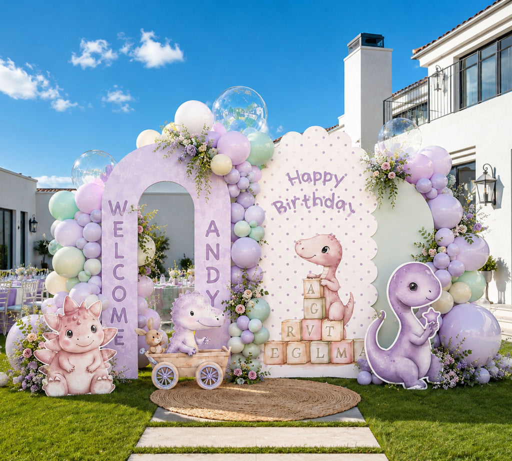 Outdoor baby dinosaur party backdrop with pastel purple and mint arch panels, balloon decor and personalized dino birthday styling.