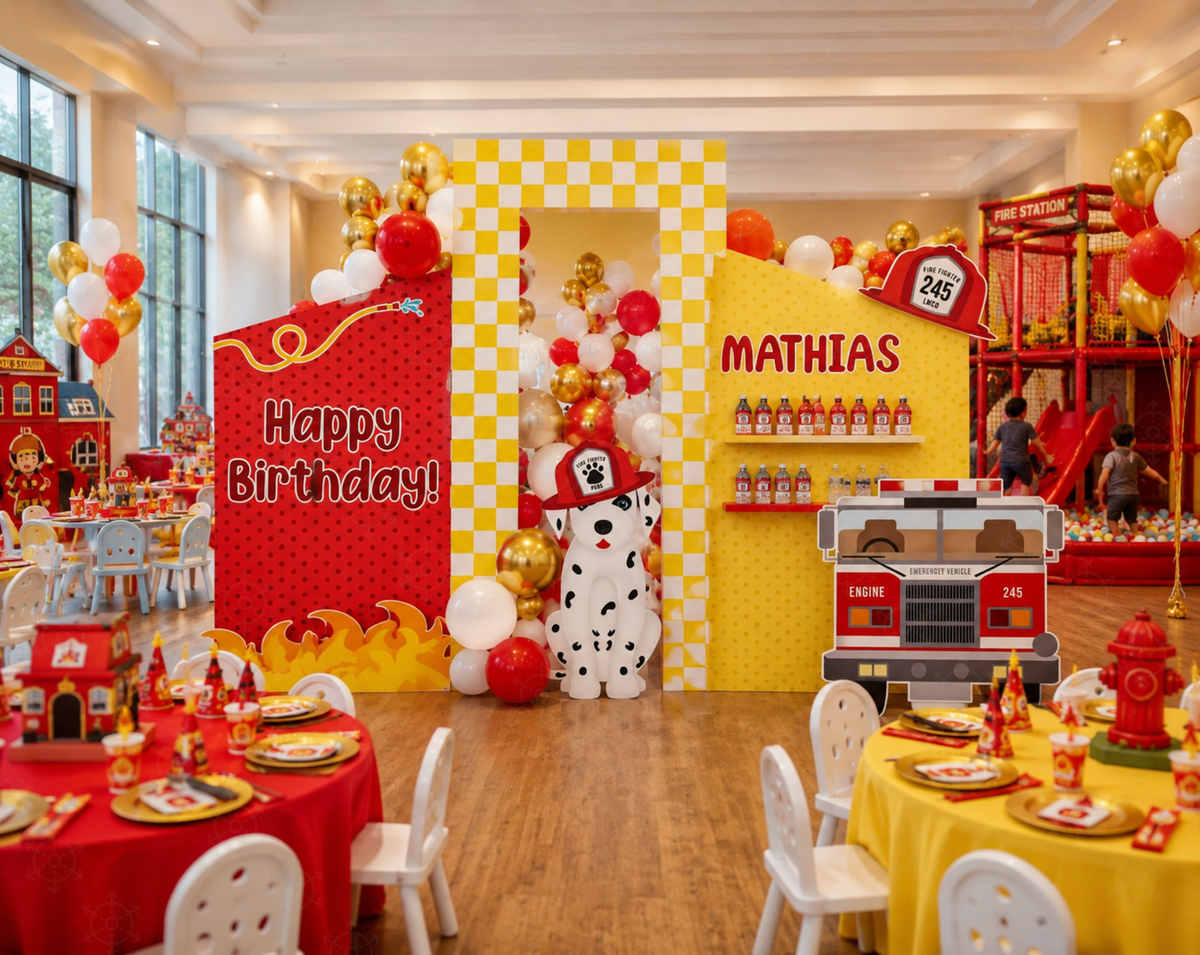 Personalized fire truck party decorations with red and yellow backdrop panels, caution sign accents, balloon clusters and matching kids tables.