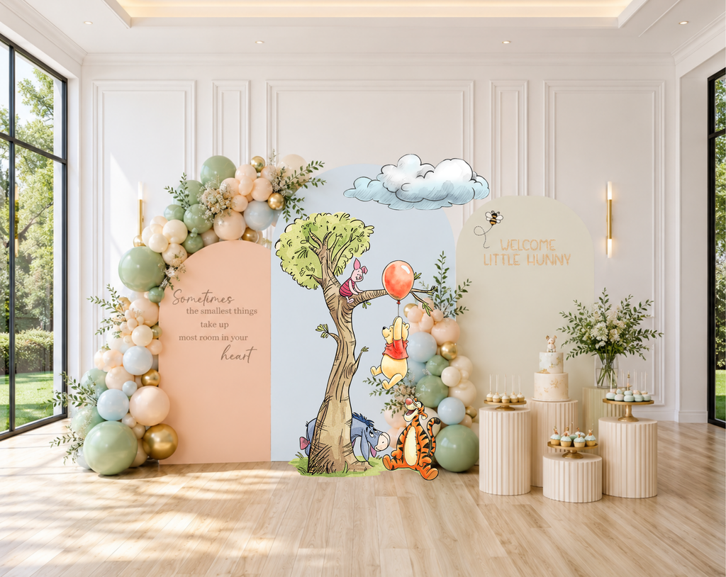 Pastel woodland baby shower setup with peach backdrop panel, floral balloon accents and sweet classic bear character cutouts.