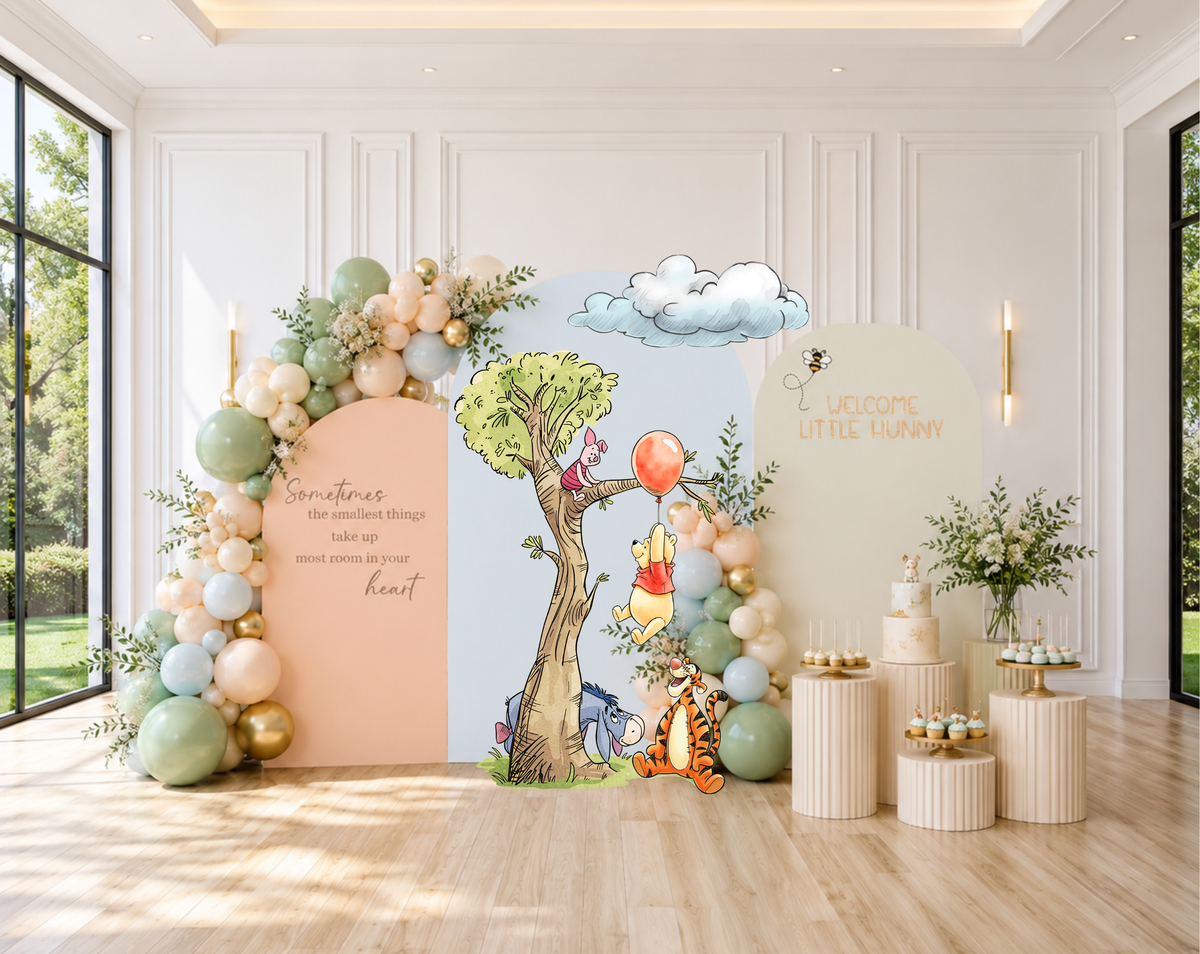 Pastel woodland baby shower setup with peach backdrop panel, floral balloon accents and sweet classic bear character cutouts.