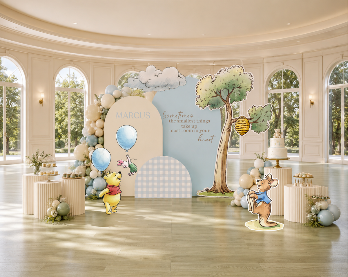 Soft blue woodland birthday backdrop with classic bear inspired characters, balloon garland and personalized storybook party decorations.