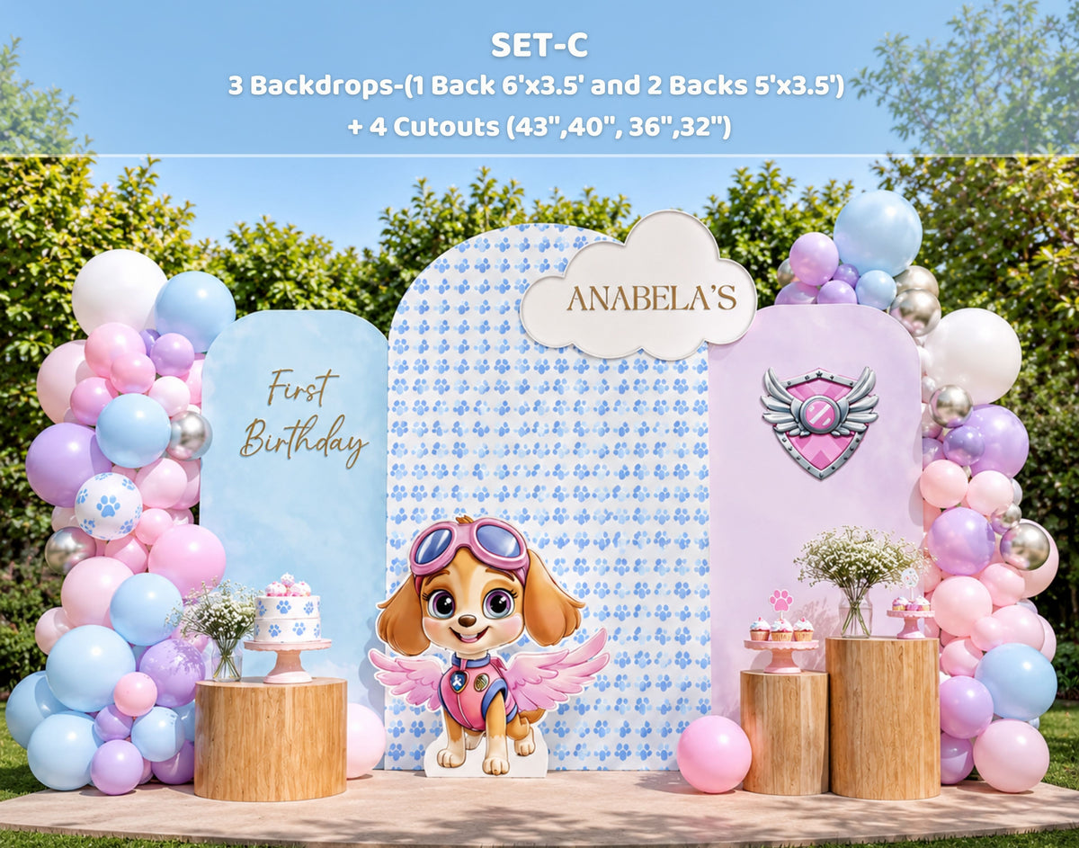 Outdoor pink puppy party backdrop with pastel panels, balloon garland and character cutouts for a playful birthday setup.