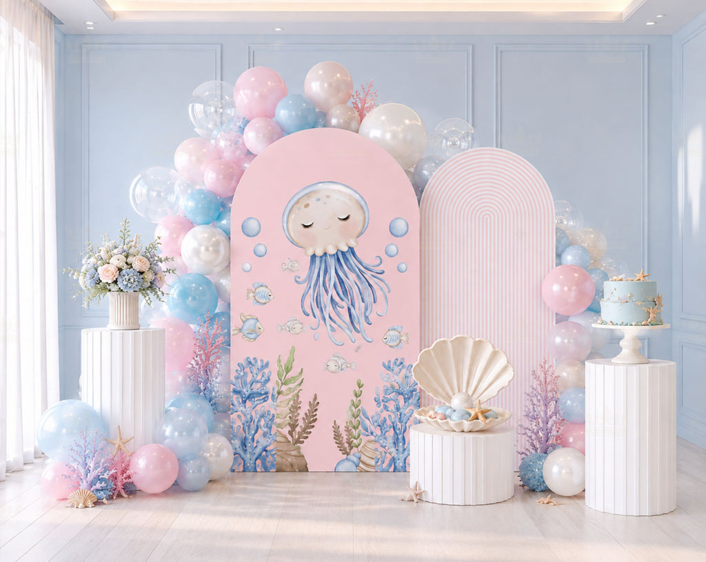 Pink ocean animals birthday backdrop with balloon garland, sea themed decor and pastel under the sea party styling.