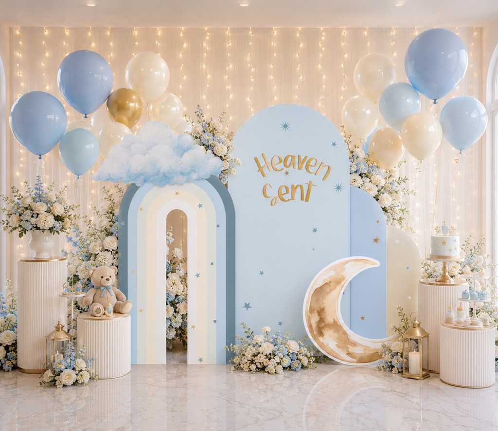 Celestial baby boy backdrop with blue and white arches, moon and star details, cloud accents and personalized baby shower decorations.