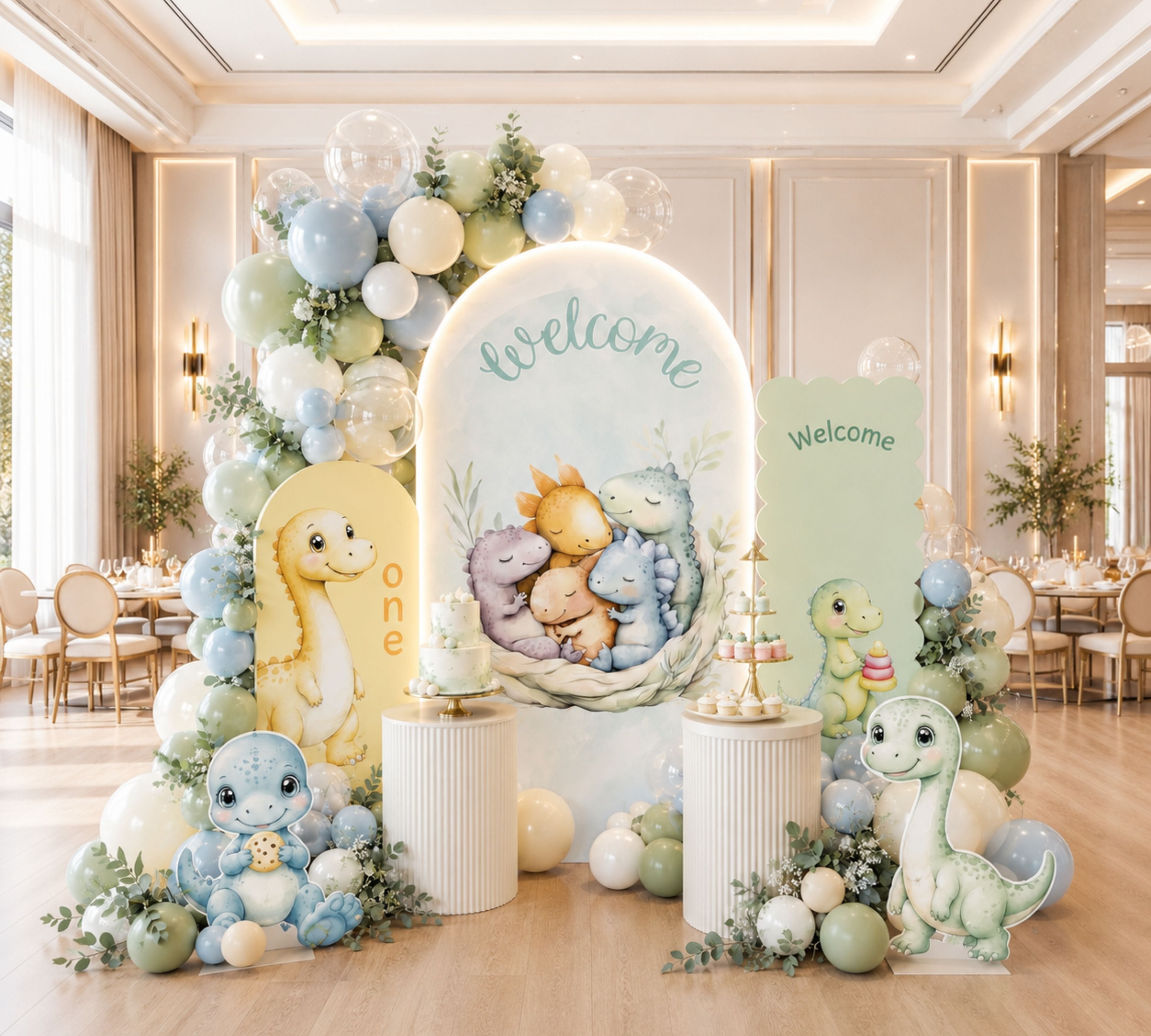 Personalized dino birthday backdrop with sage and ivory arch panels, balloon clusters and baby dinosaur party decor.