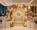 Natural wood quinceañera papel picado backdrop with number 15 and warm neutral floral decorations
