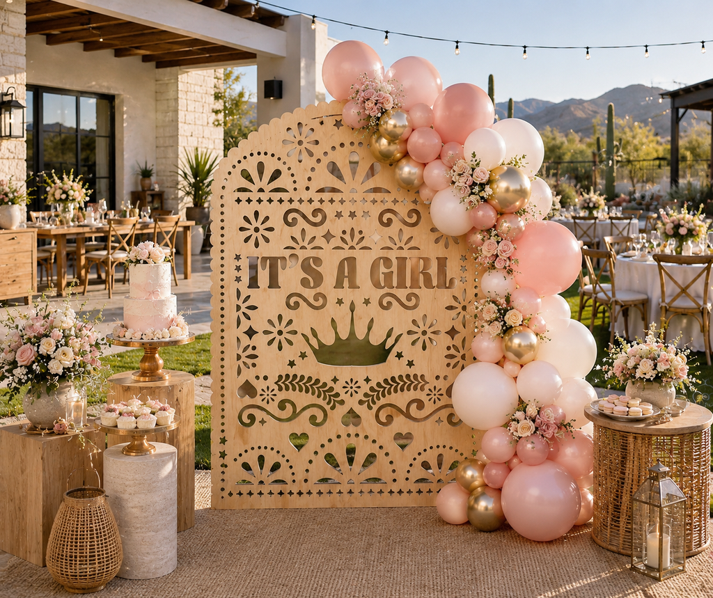 Blush papel picado backdrop with It's a Girl design and pink baby shower decorations