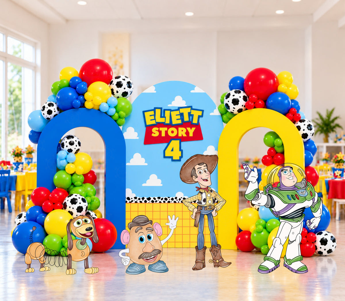 Bright western toy birthday backdrop with red blue yellow and green panels, sheriff-inspired styling and colorful balloon decorations.