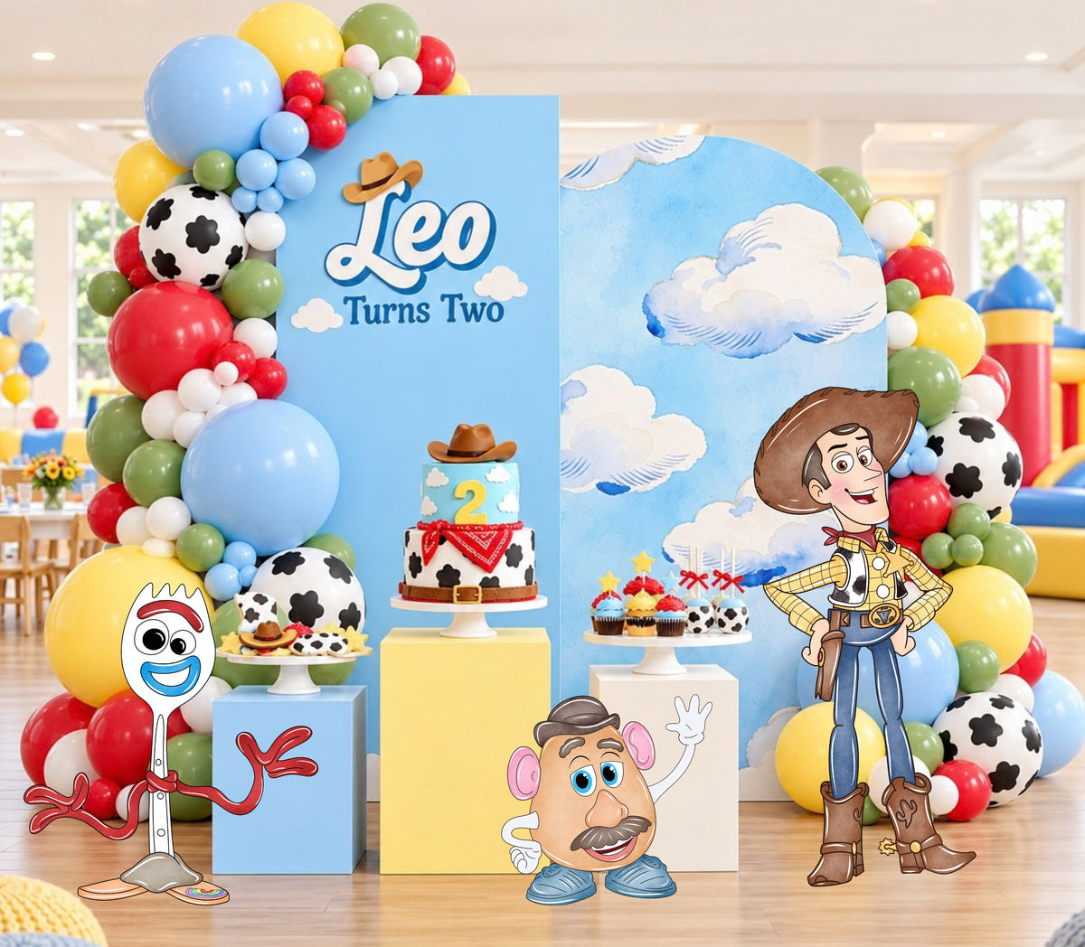 Pastel western birthday backdrop with soft blue pink and yellow panels, toy character cutouts and personalized kids party decor.