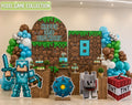 Personalized pixel game birthday backdrop with grass block panels, turquoise number detail, balloon garland and character cutouts for a gamer themed party.