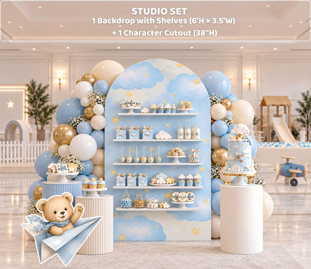 Aviator bear birthday backdrop with integrated shelves, soft blue panels, neutral balloon decor and coordinated baby boy party styling.