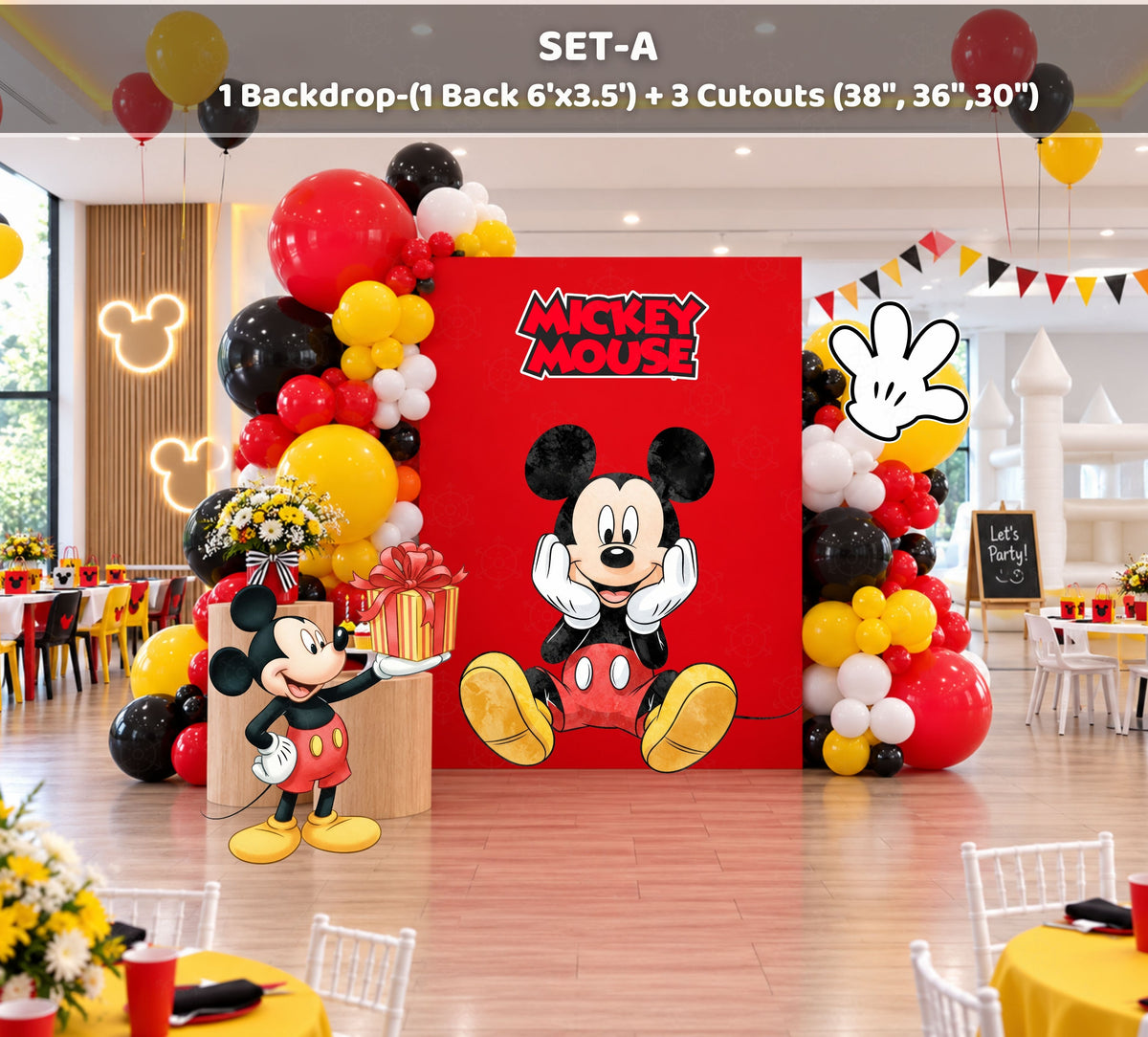 Classic mouse birthday photo area with red and black backdrop panels, balloon garland and coordinated themed decorations.