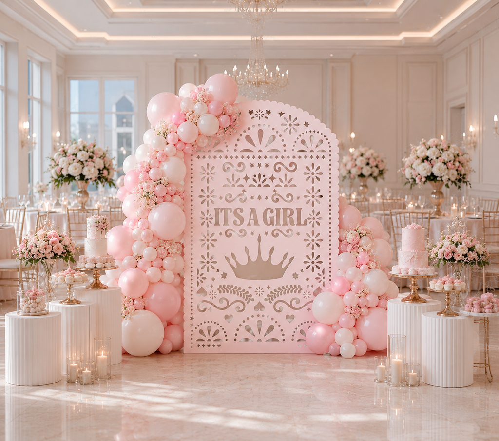 Pink papel picado baby shower backdrop styled with soft pink balloons and elegant decor