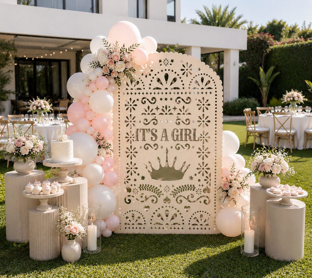 Blush pink papel picado baby shower backdrop with floral decor in outdoor celebration