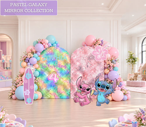 Pastel blue and pink alien birthday backdrop set with colorful balloon garland, arched panels and matching character cutouts for a whimsical kids party.