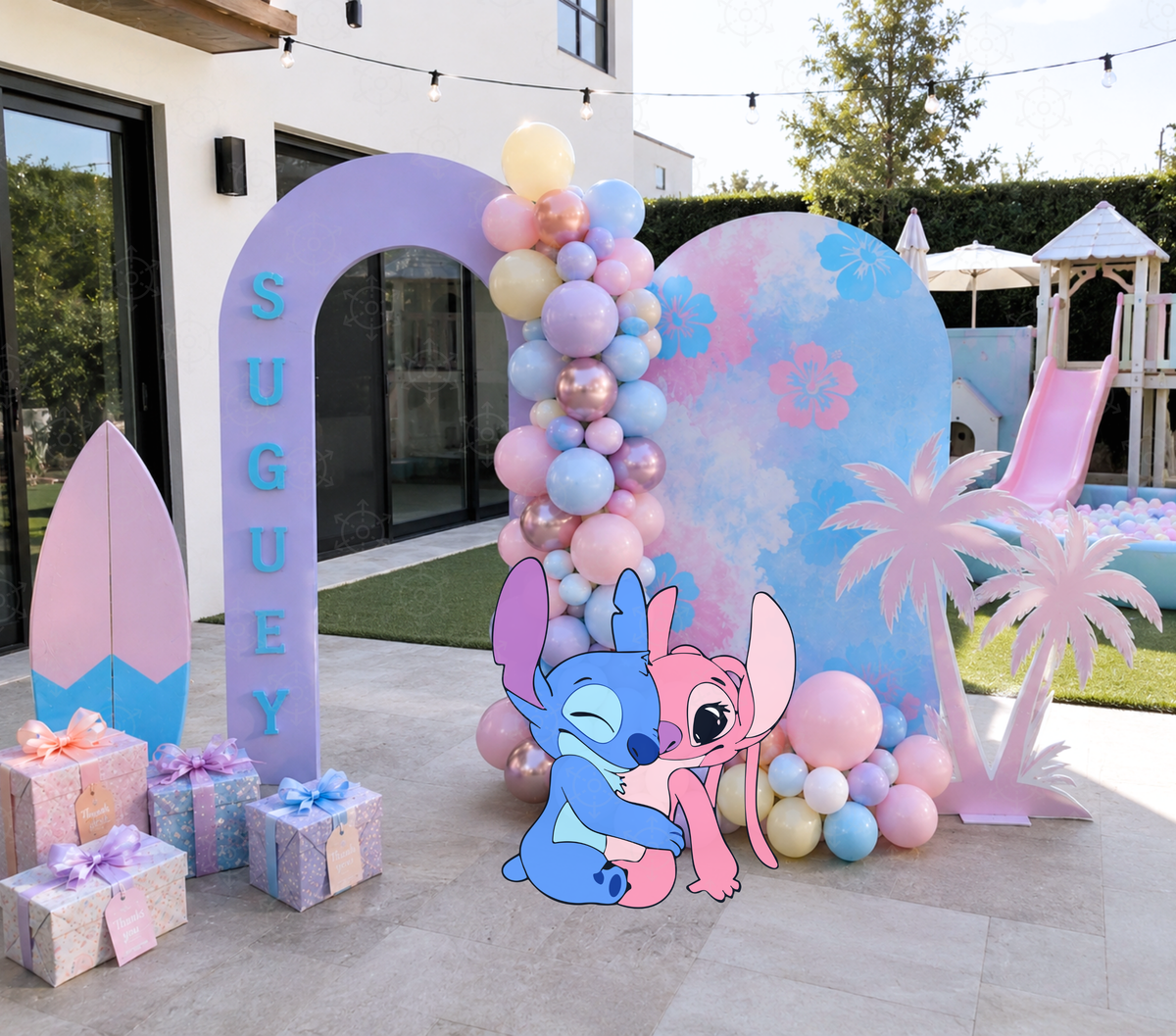 Tropical alien birthday party setup with pastel backdrop panels, soft balloon colors and blue character cutouts for a colorful celebration